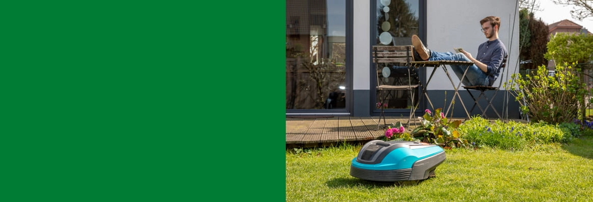 Mähroboter mäht den Rasen, während eine Person im Garten entspannt.